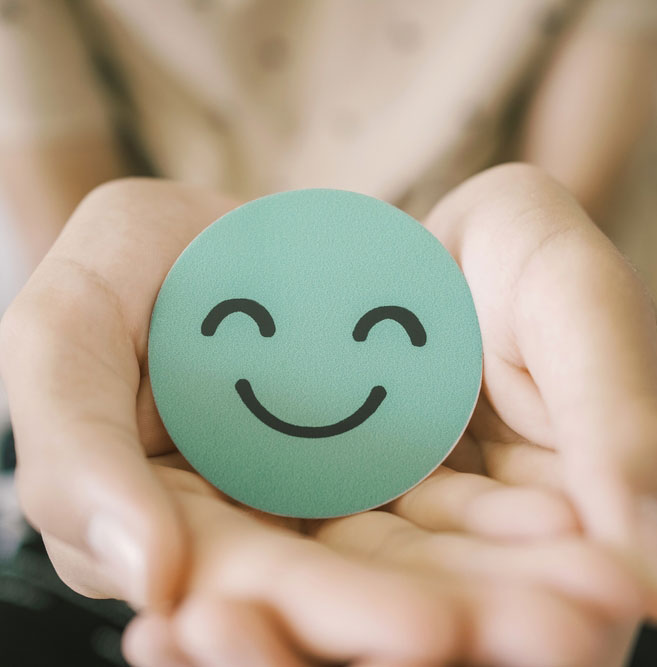 Hands holding green happy smile face